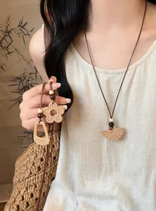 Detail of handmade bohemian woven pendant necklace with wooden beads on model.