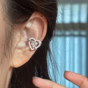 Close-up detail of a sparkling heart-shaped ear cuff with star motif on a human ear