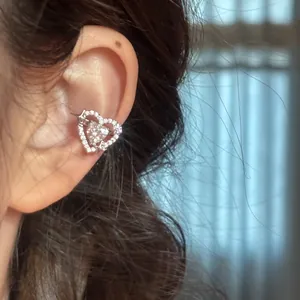 Detailed view of a sparkling zircon heart ear cuff with star motif on ear bone