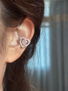 Detailed view of a sparkling heart-shaped zircon ear cuff for non-pierced ears on a model