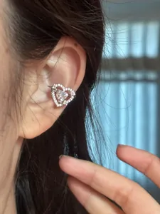 Close-up detail of a sparkling heart ear cuff with CZ stones worn on a female ear