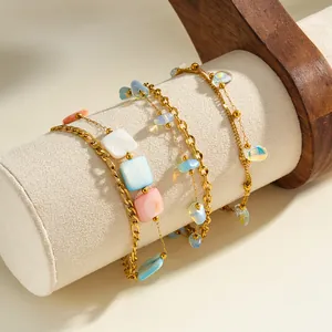 Close-up detail of gold plated stainless steel bracelet featuring colorful acrylic pendants