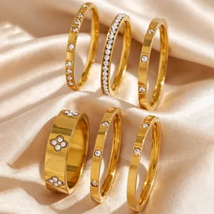 Detailed view of gold stainless steel stackable rings with zircon inlay on silk