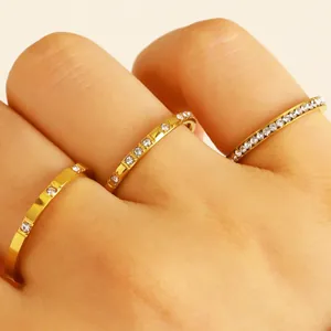 Close-up detail of gold-plated stainless steel rings with zircon accents on fingers