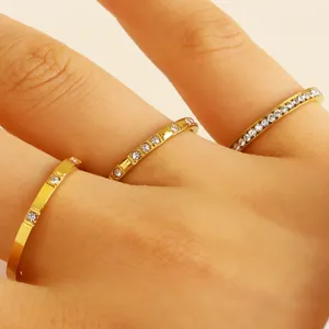 Detailed close-up of three dainty gold-tone stainless steel rings with zircon accents