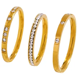Detailed view of three gold stainless steel rings with sparkling zircon settings