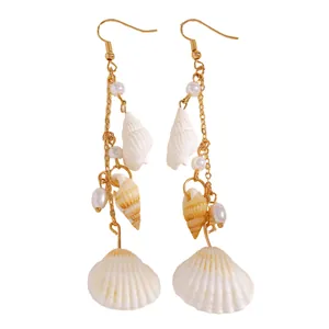 Detailed view of beach style dangle earrings with natural seashells and pearls.