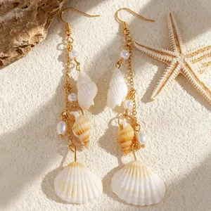 Detailed view of summer beach style earrings with sea shells, conches, and pearls