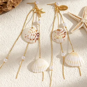Close-up detail of beach-themed long tassel earrings featuring seashells and faux pearls.