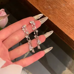 Close-up detail of elegant heart-shaped tassel earrings with shiny white zircon stones