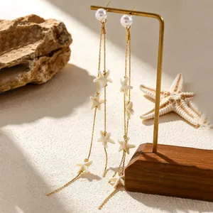 Detail view of beach-inspired long tassel earrings with pearls and white starfish charms