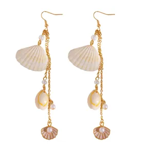 Detailed view of elegant long beach-style earrings with shells, conches and faux pearls