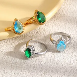 Elegantes anillos de circonita de gota en oro y plata con piedras azules y verdes.