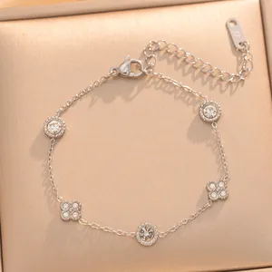 Close-up of a gold-plated titanium steel bracelet featuring zircon flower and circle charms