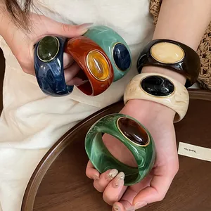 Assorted chunky acrylic marbled bangles featuring oval resin stones in vintage color palettes