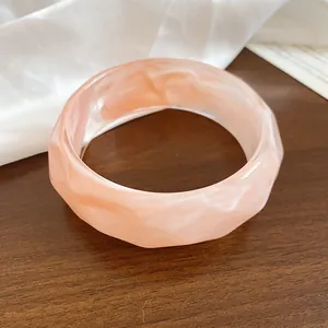 Vista macro dettagliata della trama liscia e del bordo ondulato di questo bracciale rosa