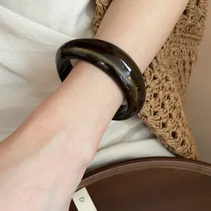 Detailed view of an irregular geometric acrylic marbled bangle with smooth glossy finish
