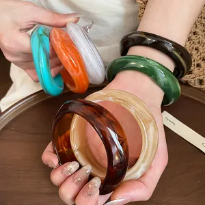 Detailed view of colorful marbled acrylic bangles with irregular geometric shapes