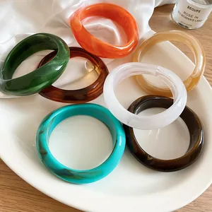 Close-up of assorted irregular acrylic marbled bangles with vibrant colors and resin textures