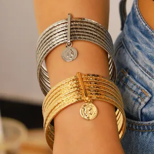 Close-up of vintage multi-layer bracelets with star texture and coin pendant detail.