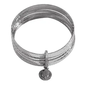 Macro view of multi-layer hammered silver bangle with embossed queen coin pendant