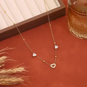 Primo piano di una delicata collana in acciaio inossidabile con ciondoli a cuore di strass.