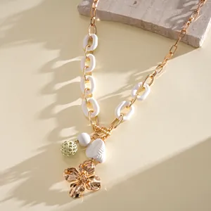 Gros plan du collier pendentif fleur dorée avec maillons en acrylique et métal