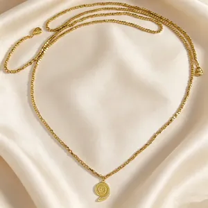 Primo piano dettagliato di una collana di perline dorate con ciondolo a conchiglia su raso