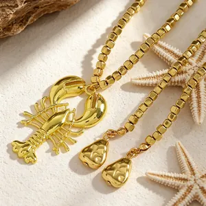 Primo piano della collana dorata con ciondolo a forma di aragosta e perline quadrate