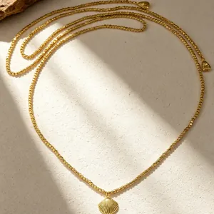 Dettaglio di una collana di perline CCB dorate in stile boho con ciondolo conchiglia