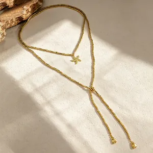Dettaglio della collana a strati in perle CCB dorate con un pendente a forma di stella marina.