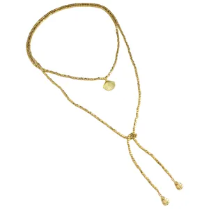 Dettaglio ravvicinato della collana con perline CCB dorate e ciondolo a conchiglia.