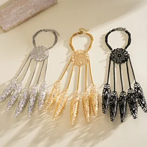 Three colors of hollow-out finger cot bracelets with hand chains on a beige surface