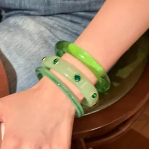 Eleganti bracciali a cerchio in resina verde impilabili con pietre verdi incastonate.