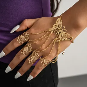 Close-up detail of a gold hollow butterfly finger sleeve bracelet worn on a woman's hand