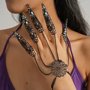 Macro detail of black filigree finger armor bracelet with intricate floral mandala design