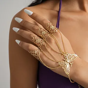 Detailed view of an elegant gold butterfly finger-to-wrist harness bracelet on a model