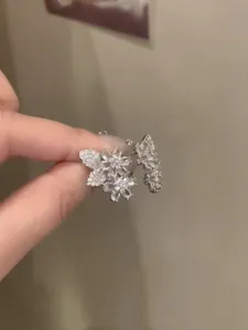 Dettaglio ravvicinato di orecchini scintillanti a forma di fiore e foglia con zirconi