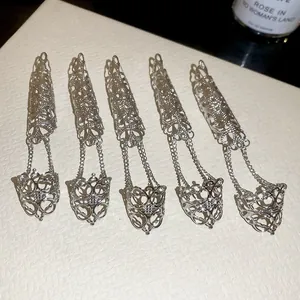 Detail van gotische zilveren kettingringen met holle nagelcovers en kettingen.