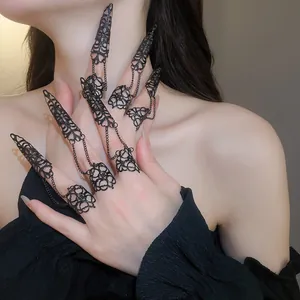 Detailopname van gotische zwarte holle vingerringen met delicate ketting handjuwelen