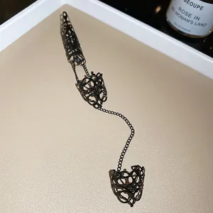 Detail van gotische zwarte handketting met opengewerkte ringen en nagelbedekking