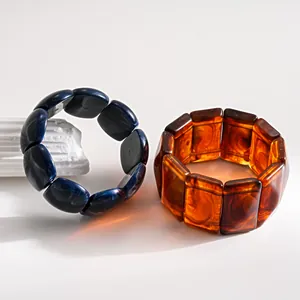 Detailed close-up view of retro marbled acrylic bracelets in amber and navy blue colors.