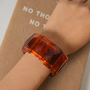 Detailed view of a vintage amber acrylic marbled rectangular geometric bracelet on arm