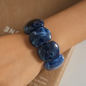 Close-up of blue marbled acrylic rectangular beads on a vintage-style bracelet
