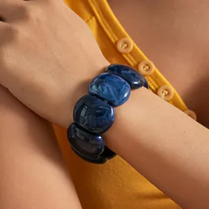 Close-up of a stylish blue marbled acrylic bangle bracelet with a vintage aesthetic