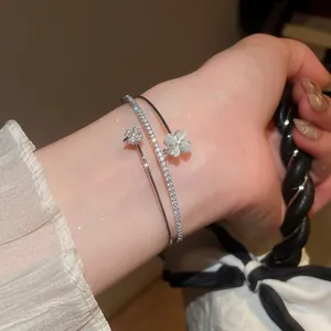 Detaillierte Nahaufnahme eines zweilagigen Silberarmbands mit funkelnden Kleeblättern