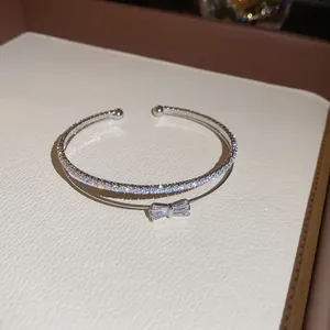 Nahaufnahme eines eleganten silbernen zweilagigen Armreifs mit funkelnder Zirkon-Schleife