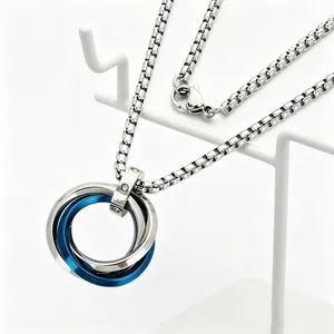 Gros plan sur un collier en acier inoxydable avec trois anneaux entrelacés bleus et argent