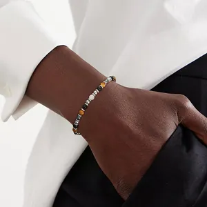 Close-up view of a healing crystal tiger eye and black hematite beaded bracelet on a wrist