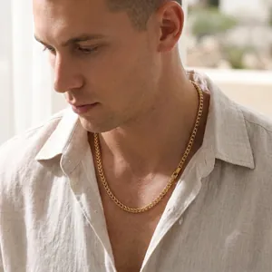 Close-up of 5mm gold stainless steel wheat chain necklace worn by a male model in daylight.